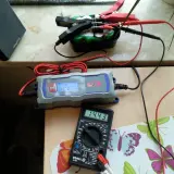 Ładowarka samochodowa Ultimate Speed pokazuje 14.3V, a multimetr Vorel 14.43V. Sprawdzamy, ile ładuje się akumulator.