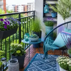 Uroczy balkon z krzesłem, stolikiem i mnóstwem kwiatów. Idealne miejsce, by usiąść i zastanowić się, co na balkon jeszcze można postawić.
