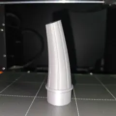 Szary lejek, wydrukowany na drukarce 3D, stoi na platformie roboczej.