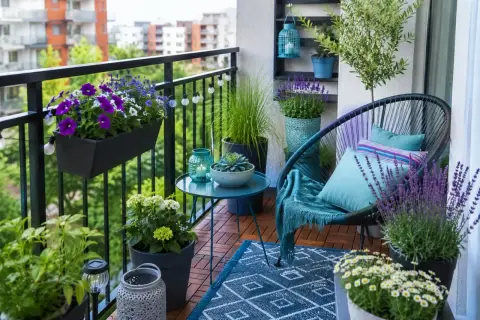 Uroczy balkon z krzesłem, stolikiem i mnóstwem kwiatów. Idealne miejsce, by usiąść i zastanowić się, co na balkon jeszcze można postawić.
