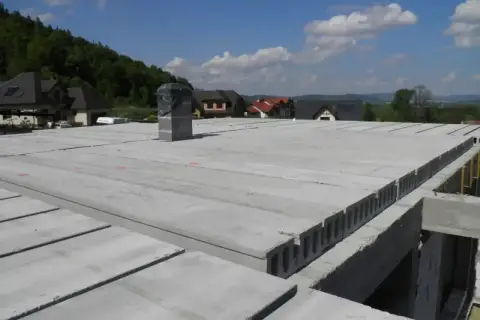 Płyty kanałowe i żelbetowe tworzą nowoczesne rodzaje stropów. Widok na budowę domu z gotowymi elementami stropowymi.