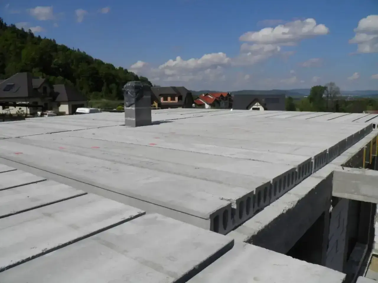 Płyty kanałowe i żelbetowe tworzą nowoczesne rodzaje stropów. Widok na budowę domu z gotowymi elementami stropowymi.